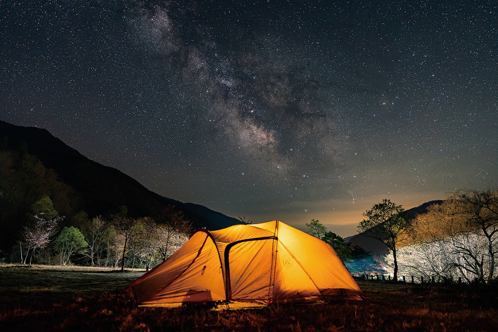 星空の下で明かりが灯るテント